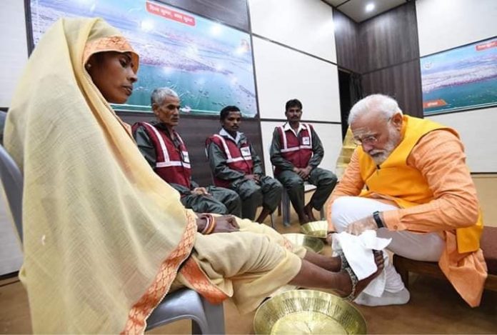 स्वच्छता दूतों के पाँव धोते हुए प्रधानमंत्री मोदी