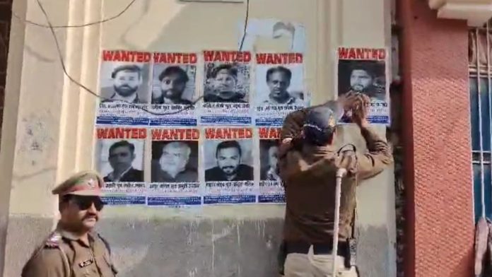 दंगाइयों के पोस्टर लगाती पुलिस