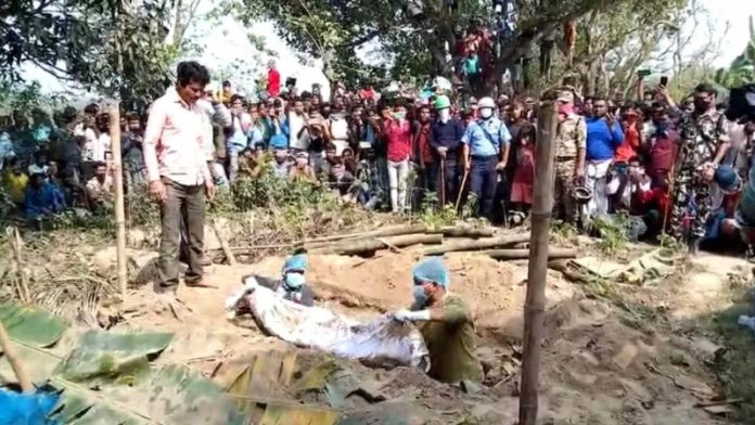 मुर्शिदाबाद में कब्र से शव निकालते कर्मचारी