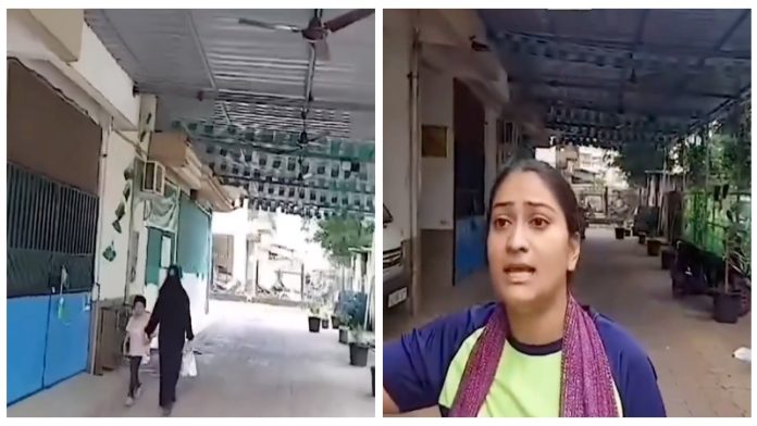 सोसायटी में अवैध बने मदरसे को दिखाती हिंदू महिला
